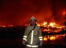 Chief Stanford in front of the Windward Harbor fire that burned for almost 24 hours